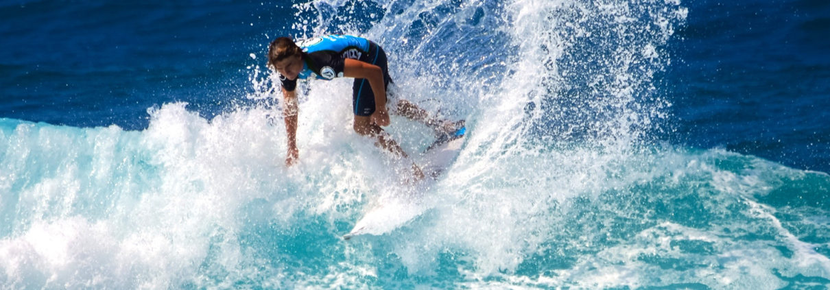 A man in blue surfing the waves