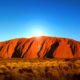 Ayers rock uluru with the sun as the background